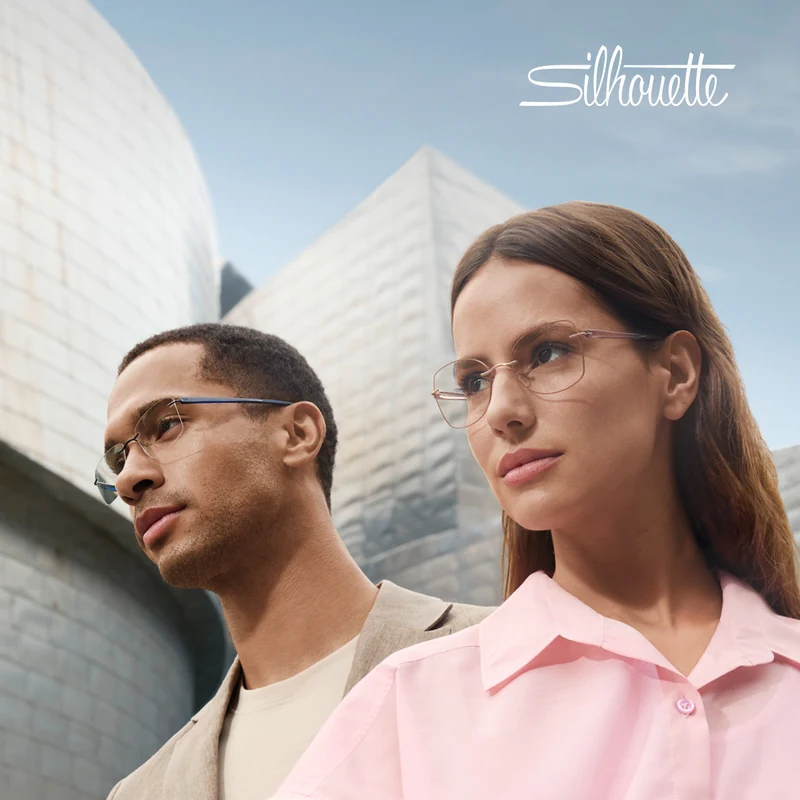 Two models wearing Silhouette rimless glasses in front of curved modern buildings